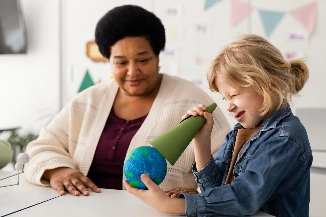 Niños estudiando los planetas en el aula.